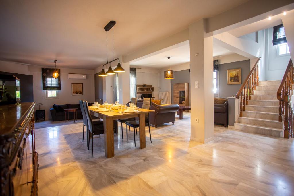 jadalnia i salon ze stołem i krzesłami w obiekcie Τraditional fully detached villa on a luxurious hillock of Thessaloniki with its own garden also for family & wedding gatherings for 10 to 25 people only 15 minutes from airport w Salonikach