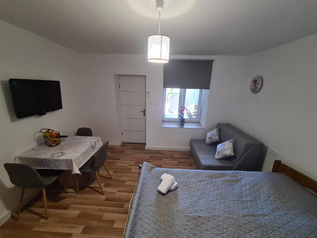 uma sala de estar com uma cama, uma mesa e um sofá em Mariola em Biograd na Moru