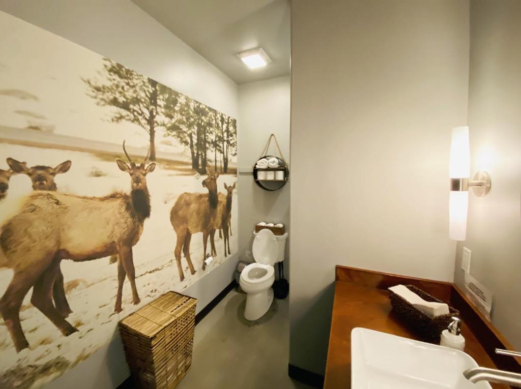 a bathroom with a painting of deer on the wall at Dreamcatcher Tipi Hotel in Gardiner