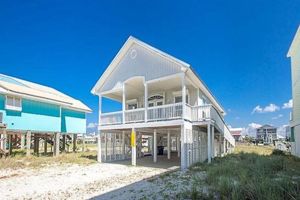 a large house on the beach next to a building at Take It Sea Z in Gulf Shores