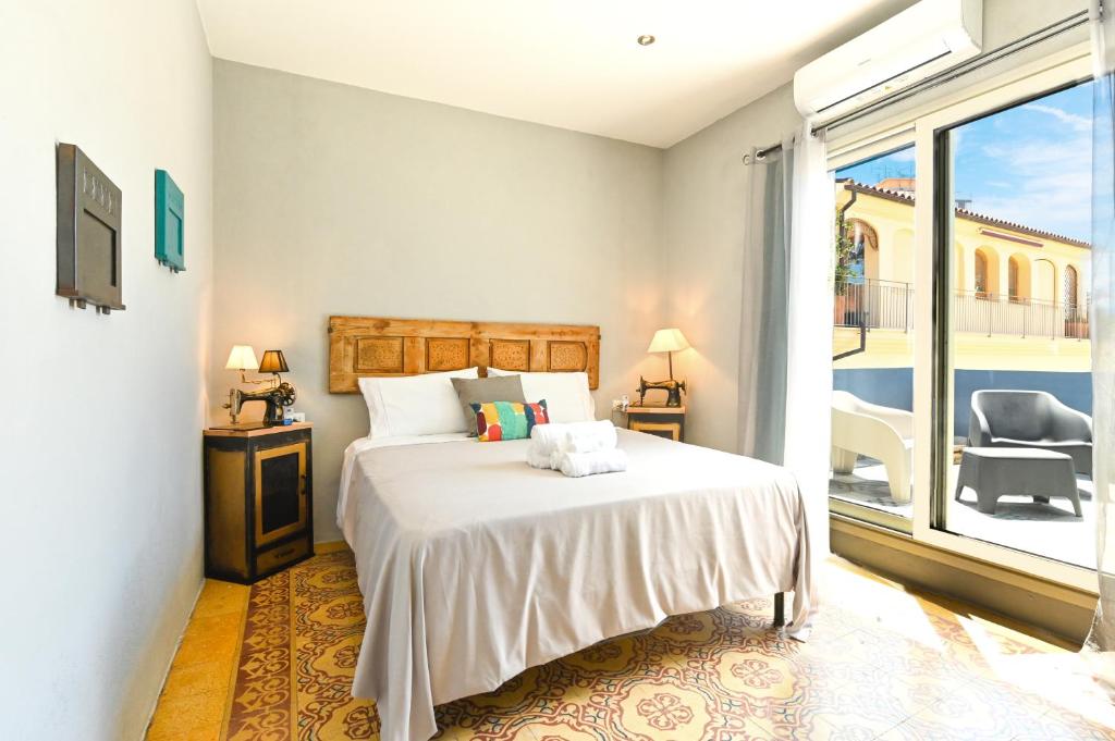 a bedroom with a white bed and a balcony at Urban Blue Guest House in Olbia