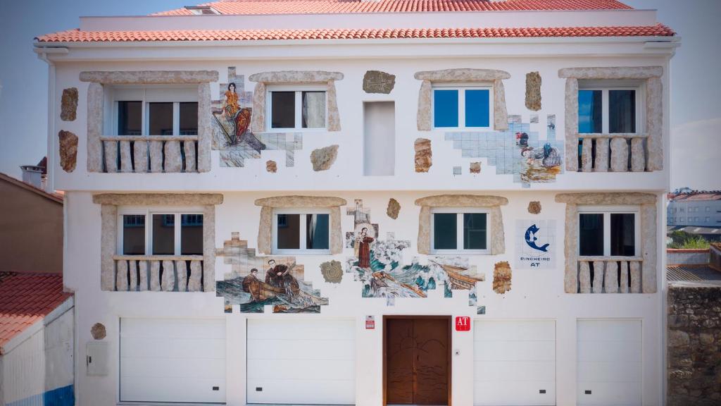 un edificio con un mural en el costado en Pincheiro Apartamentos Turísticos, en Pobra do Caramiñal