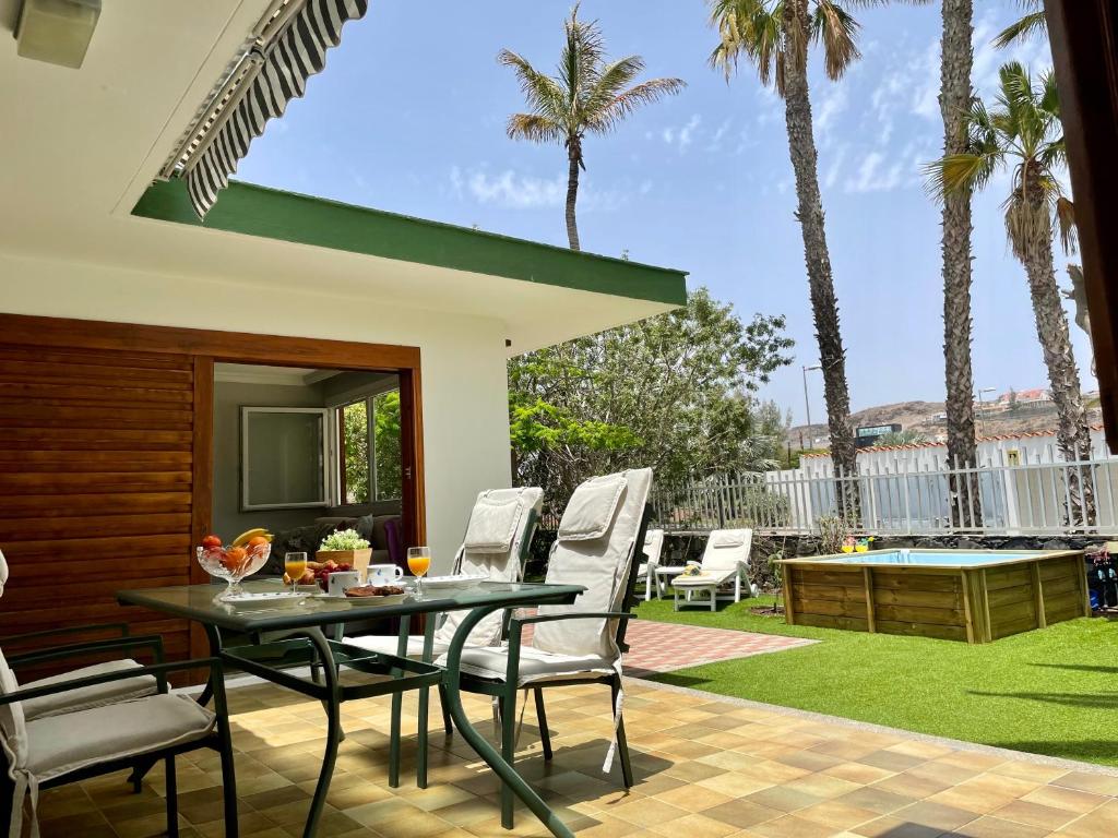 un patio con tavolo, sedie e piscina di Confortable independent Villa a San Agustin
