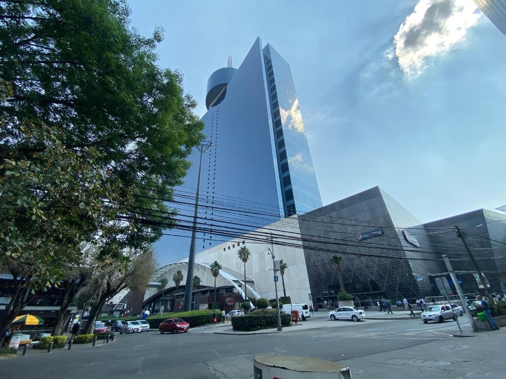 a city street with a tall building in the background at Chicago Suites WTC in Mexico City