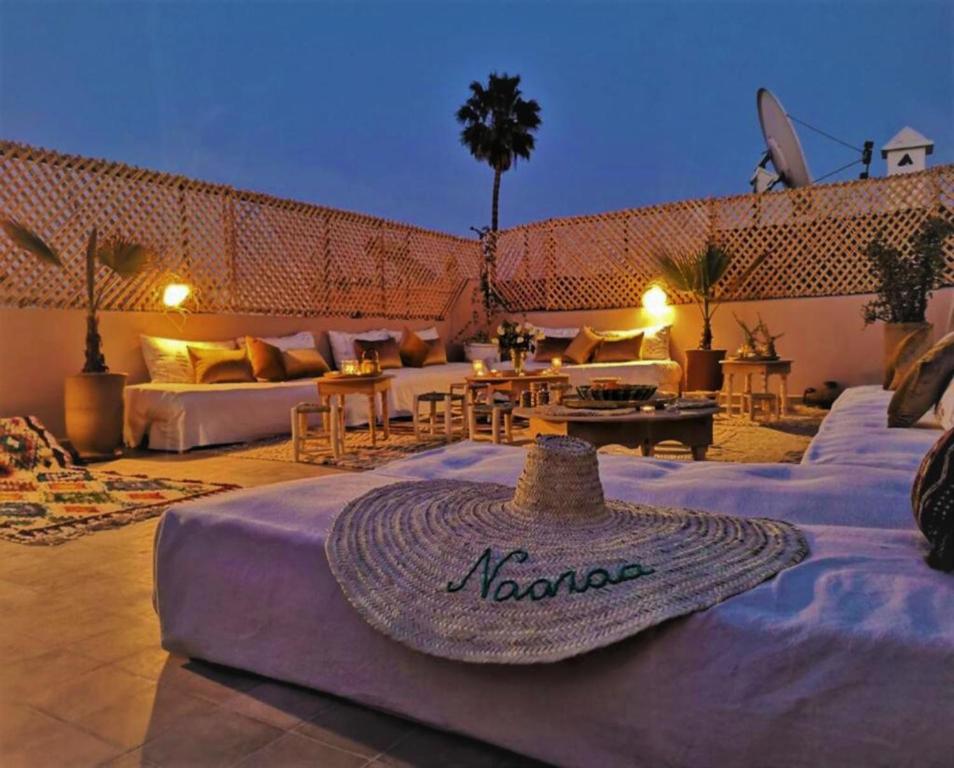 a patio with a couch and a hat on a table at Riad NaaNaa Bed & Breakfast in Marrakech