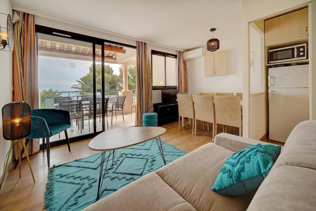 un salon avec un canapé et une table dans l'établissement IMMOGROOM - 2 Rooms sea view - Renovated - Pool - Terrace - Parking - AC, à Cannes