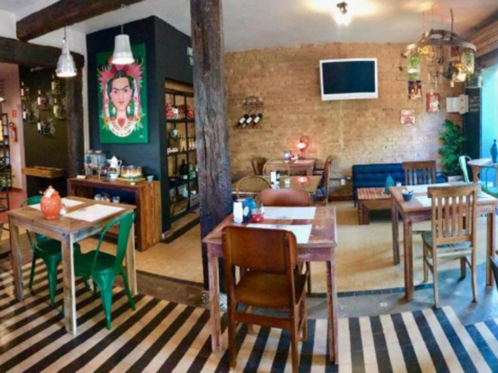 a dining room with tables and chairs in a room at Casa Alma Zen - Hostel Boutique & Bistrô Ubatuba in Ubatuba