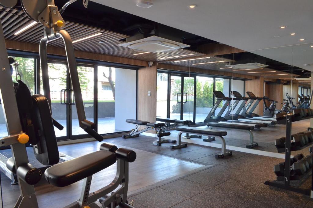 A window-lined fitness room with cardio machines, weights and a multi-gym.