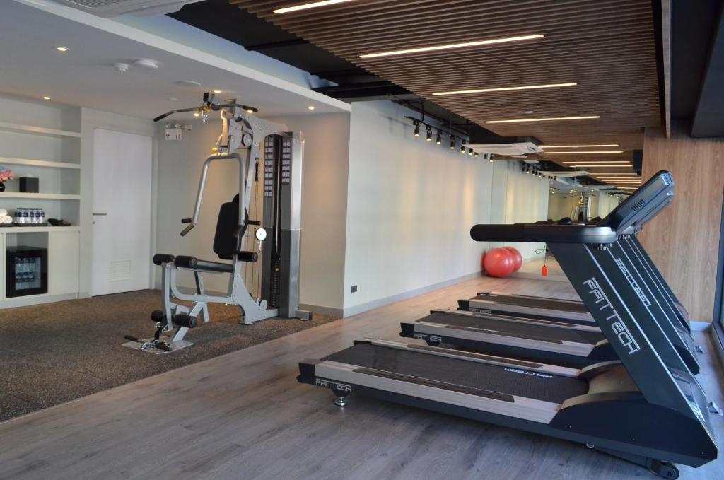 A long fitness room with several treadmills and a cable-based strength machine.