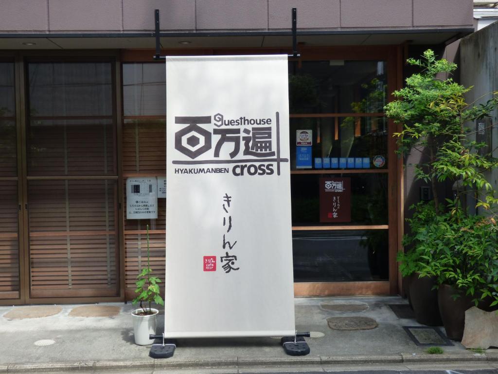 ein Schild vor einem Gebäude in der Unterkunft Guesthouse Hyakumanben Cross in Kyoto