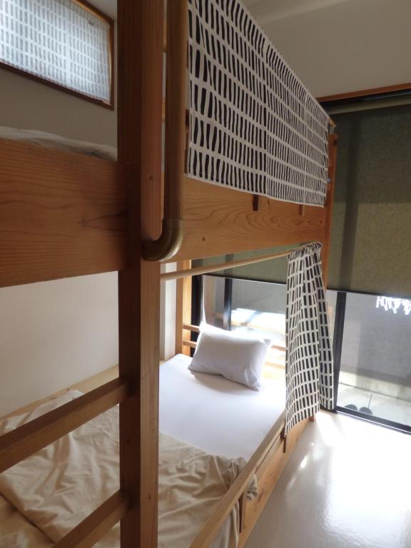 Postel nebo postele na pokoji v ubytování Guesthouse Hyakumanben Cross
