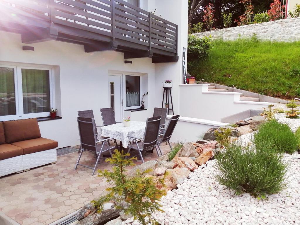 a patio with a table and chairs in a yard at Hillside Rooms in Pörtschach am Wörthersee