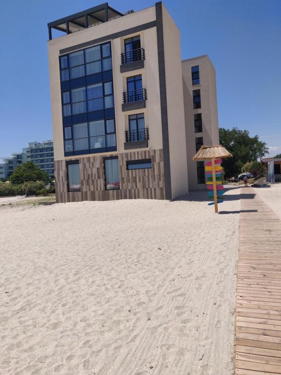 a building on the beach with an umbrella at Mamaia Beach Side in Mamaia