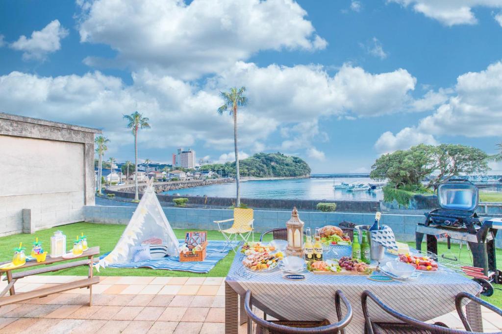 - une table de pique-nique sur une terrasse avec vue sur l'eau dans l'établissement West Coast Villa Shirahama, à Shirahama