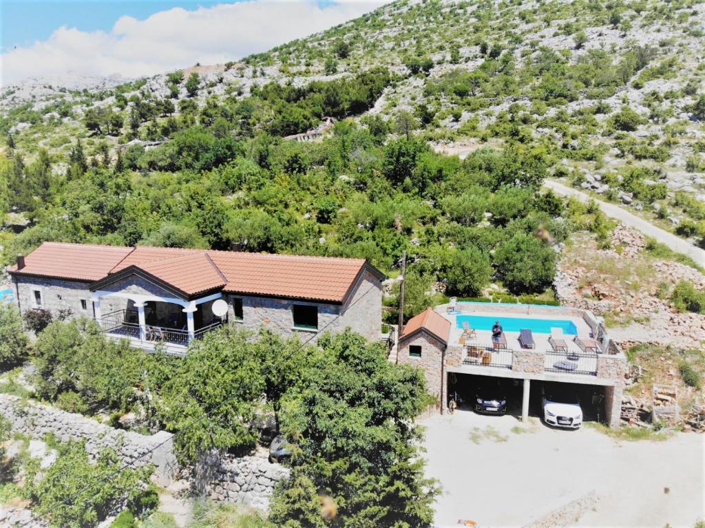 una vista aérea de una casa con una montaña en STONE VILLA-MILAN Pool Sea View Lounge Room en Starigrad-Paklenica