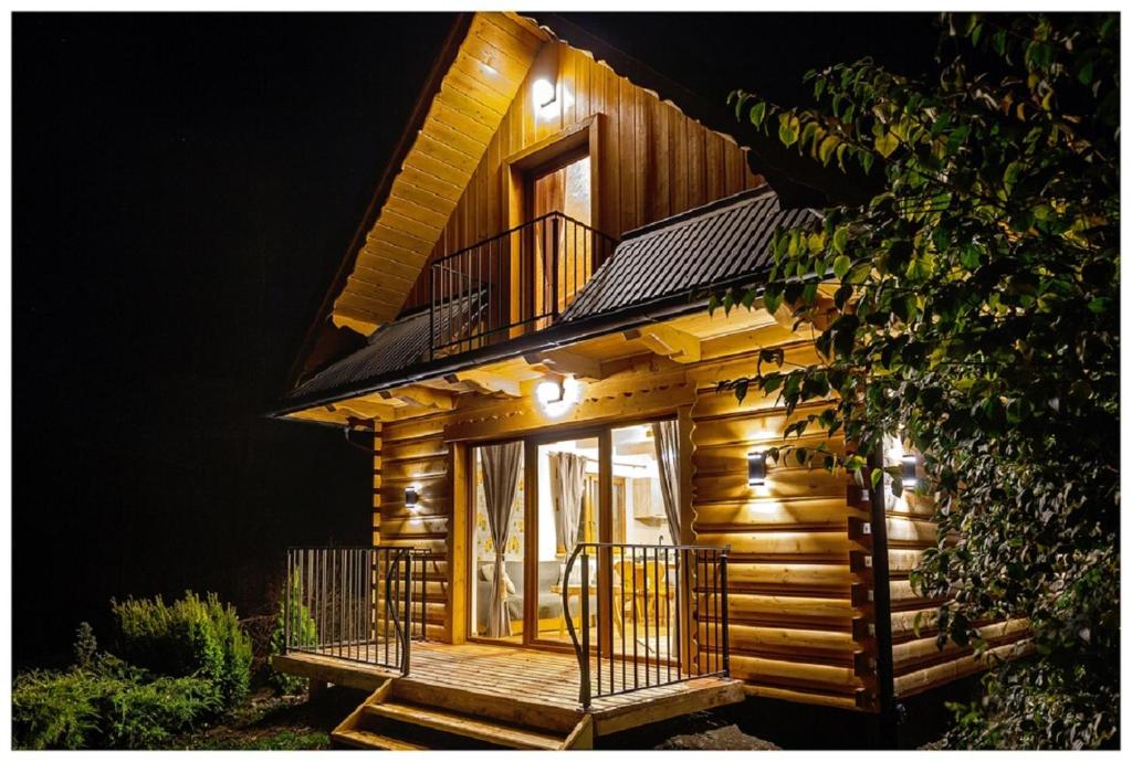 a wooden cabin with a porch and a balcony at Tatrzańska Kotwica in Witów