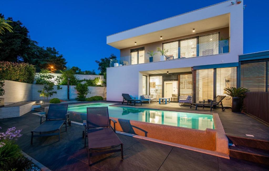 a house with a swimming pool in front of it at Luxury Villa Ane in Malinska
