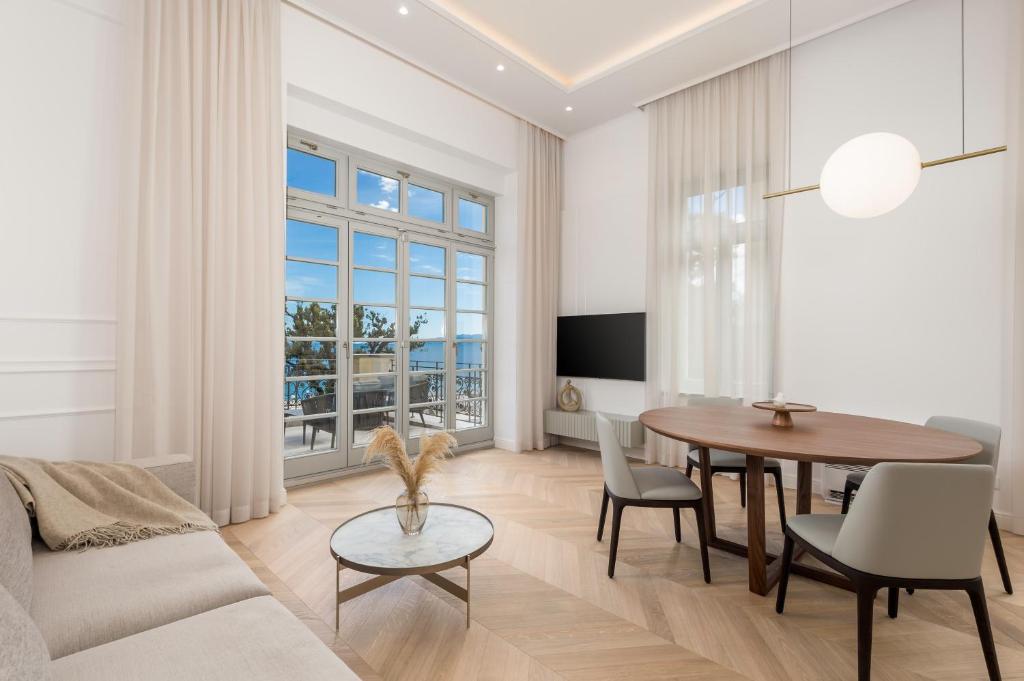 a living room with a table and a couch at Plaza Apartments in Opatija
