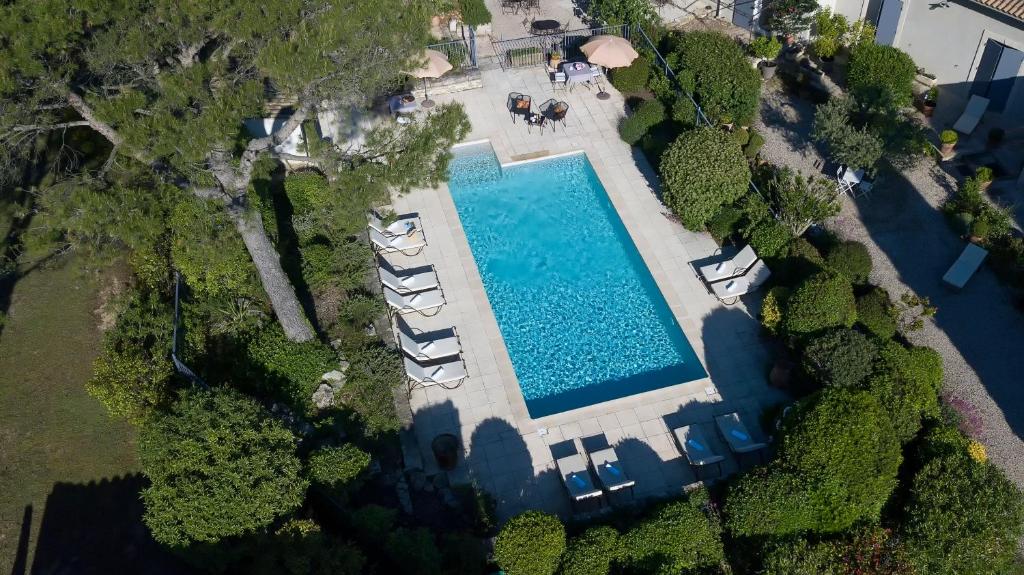 - une vue sur la piscine et ses chaises longues dans l'établissement Les Mazets de Marie de Jules, à Eyragues