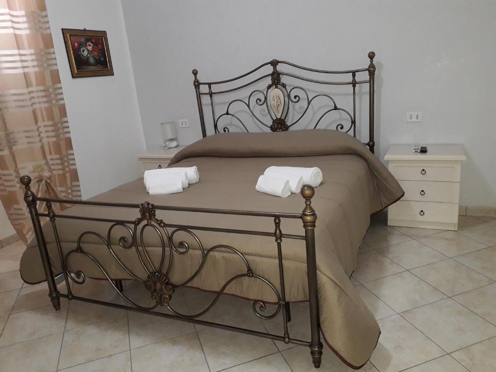 a bed with two white towels on top of it at Apartment La Maison in Messina