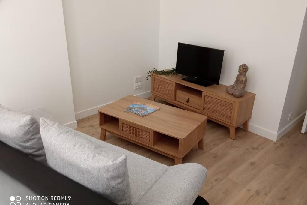 a living room with a tv and a coffee table at Appartement zen 1er étage in Cherbourg en Cotentin