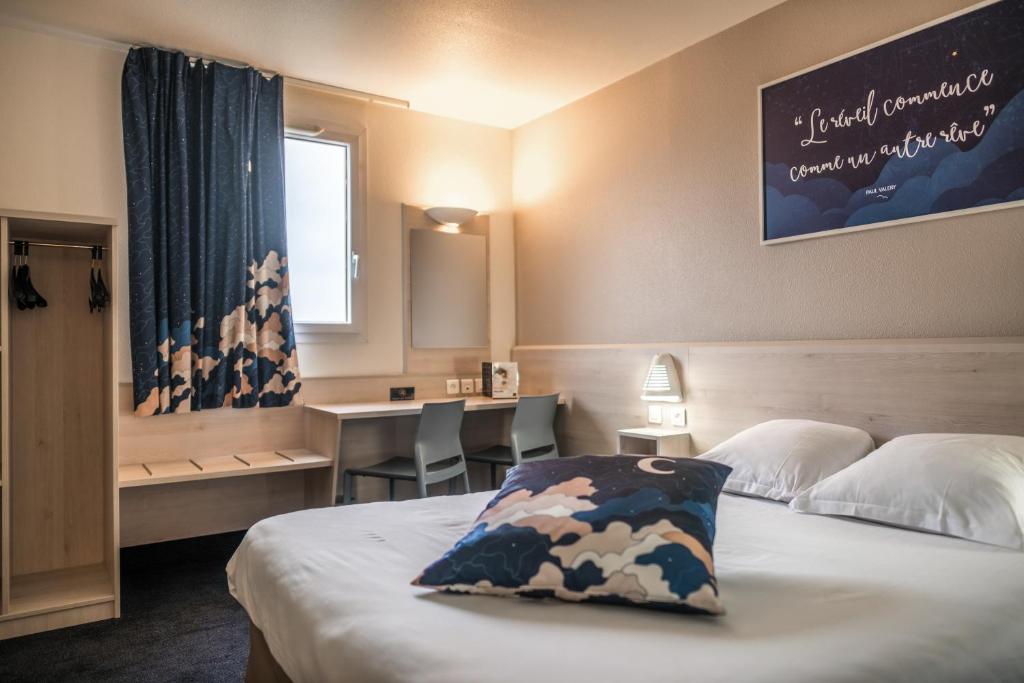 Habitación de hotel con cama, escritorio y ventana en ACE Hôtel Rouen Parc des Expositions en Le Petit-Couronne