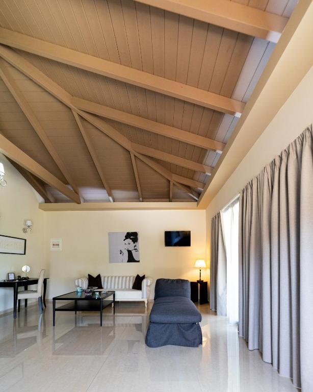 a living room with a wooden ceiling at Ornella Beach Resort & Villas in Syvota
