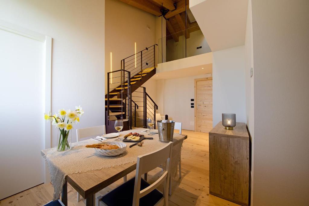 a dining room with a table and a staircase at Tenuta Grimaldi Wine Resort in Matelica