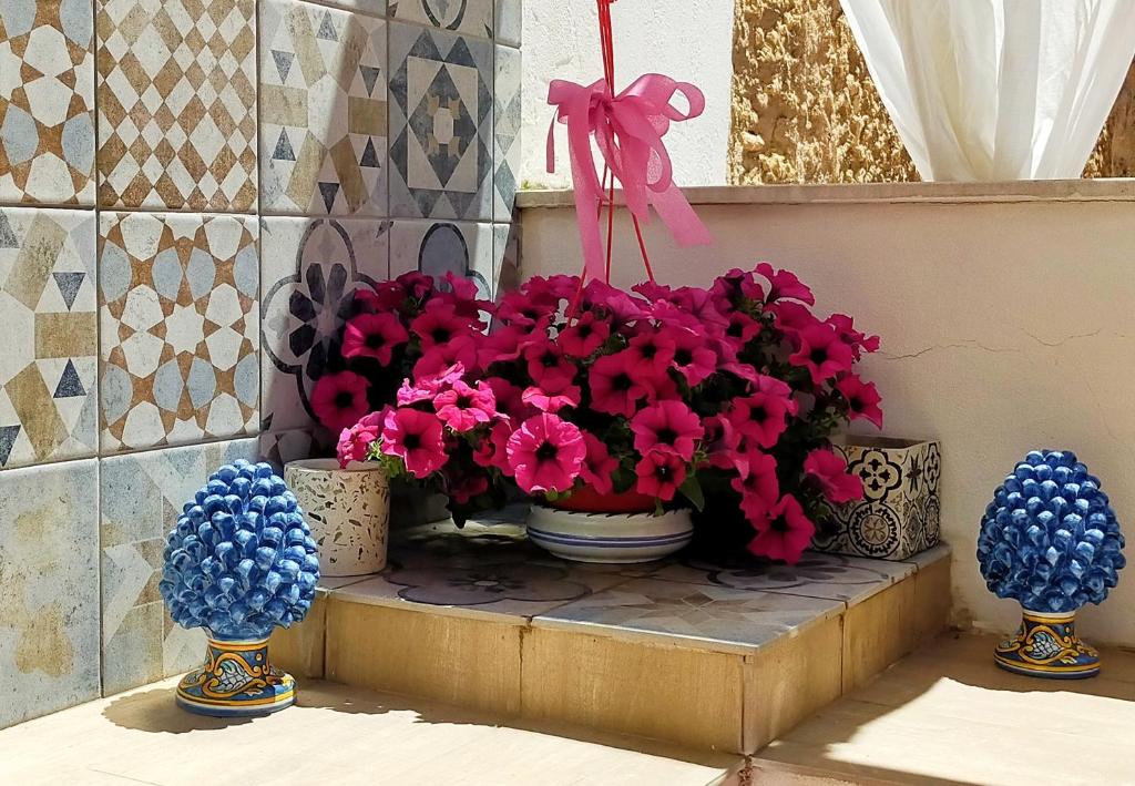 a group of potted flowers in vases on a ledge at Le terrazze segrete in Palermo