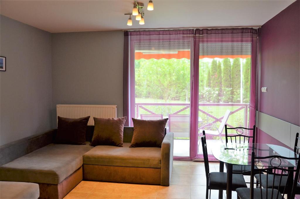 a living room with a couch in front of a window at Vadszilva Apartman in Balatonőszöd