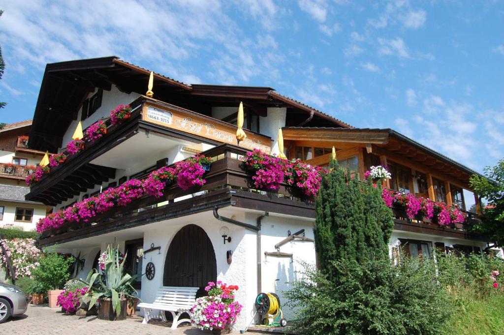 un edificio con flores a un lado. en Hotel - Pension - Heidelberg, en Ruhpolding