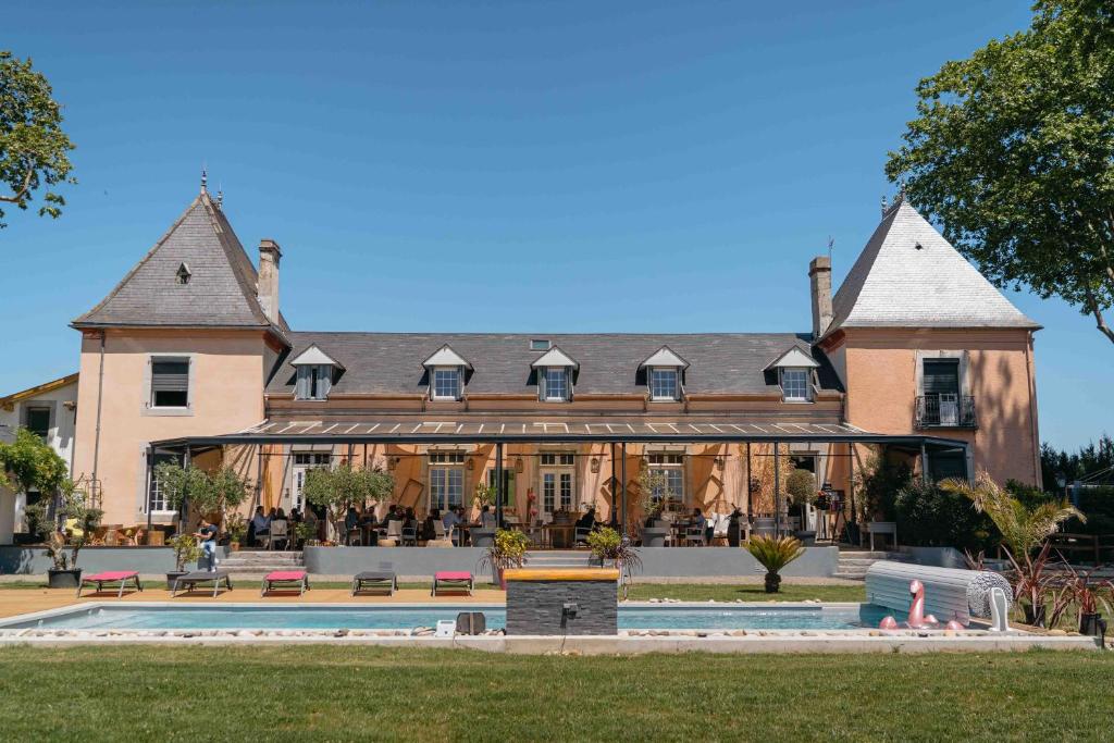 un gran edificio con una piscina frente a él en BOUTIK Hotel O'Domaine, en Chis