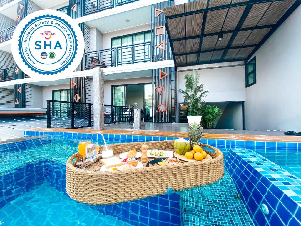 una piscina del complejo con una mesa con fruta. en Irin Beach Cha-am, en Cha Am