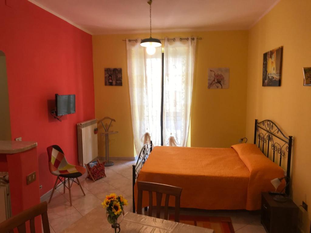 um quarto com uma cama, uma mesa e uma janela em L'APPARTAMENTINO DIAMOND em Frosinone
