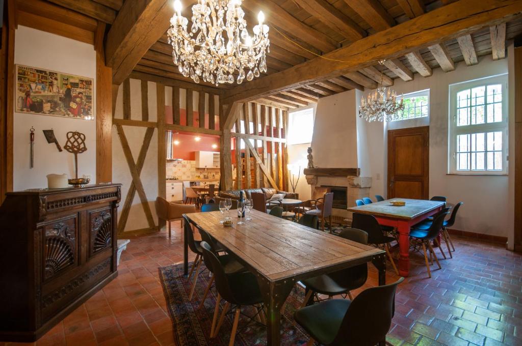 a dining room with tables and chairs and a chandelier at Maison La Ruelle des Chats Centre Historique de Troyes in Troyes