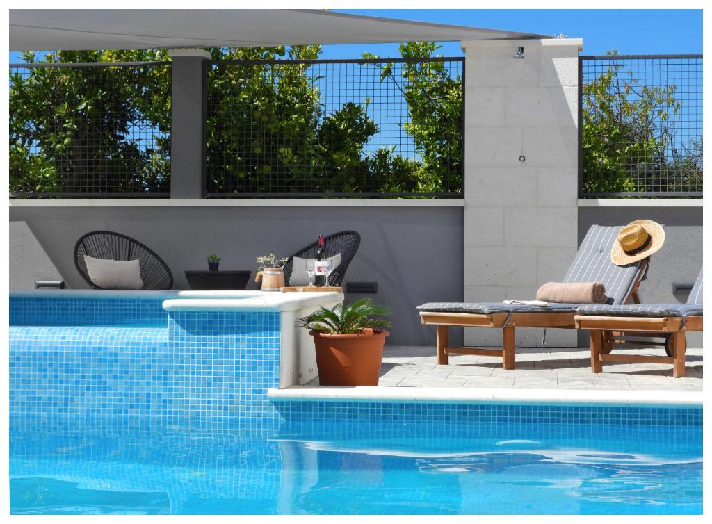 un patio con piscina, sedia e tavolo di VILLA WHITE ROSE Kaštela a Kaštela (Castelli)