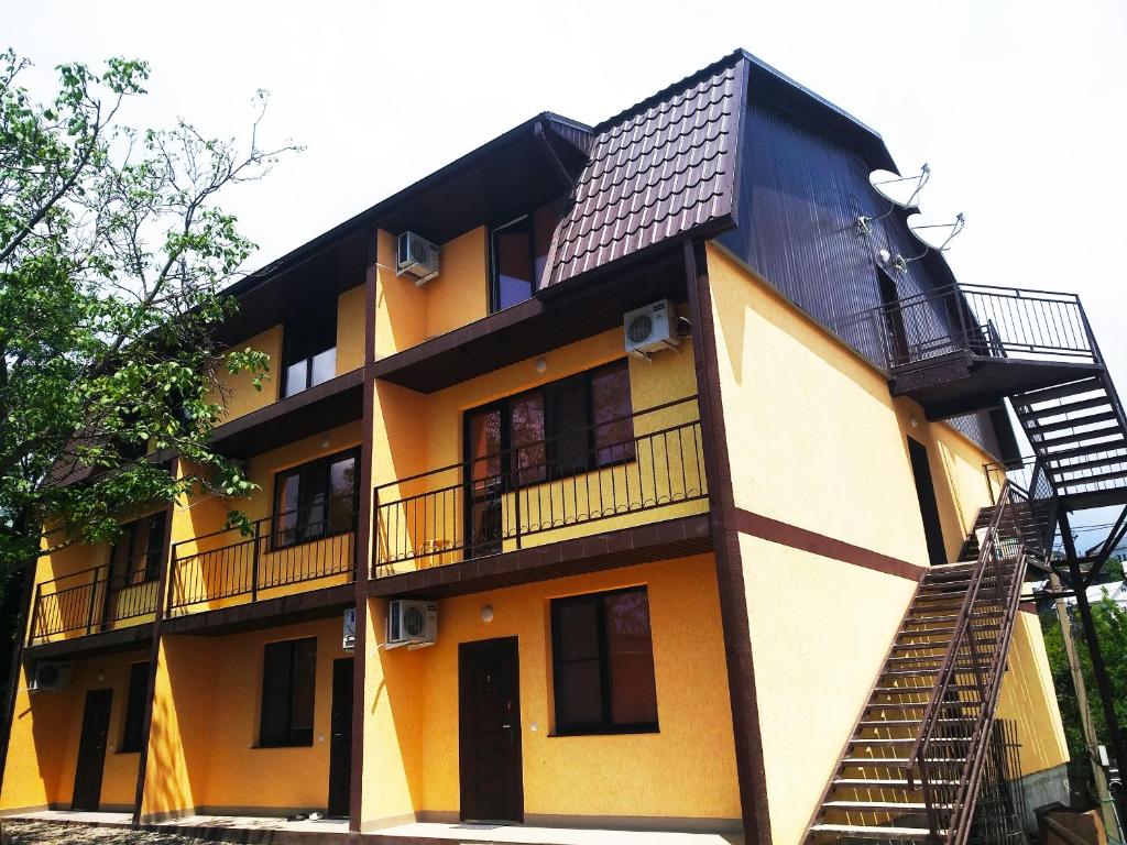 アゴイにあるKolibri Guest Houseの黒屋根の黄色い建物