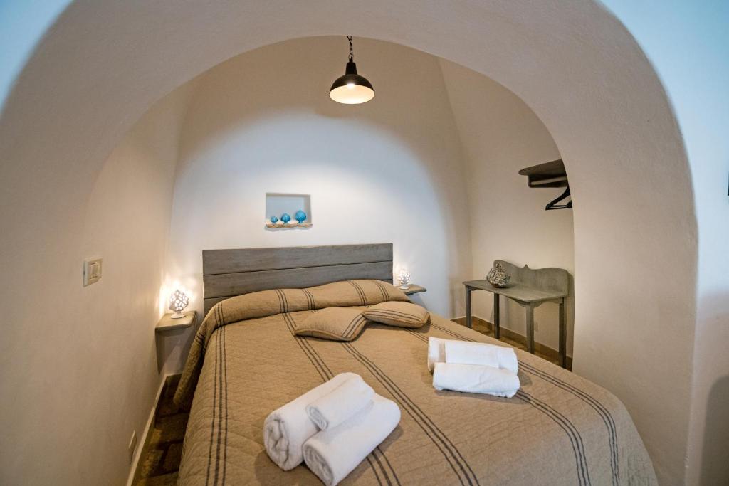 a bedroom with a large bed with two towels at Trullo 11 in Alberobello