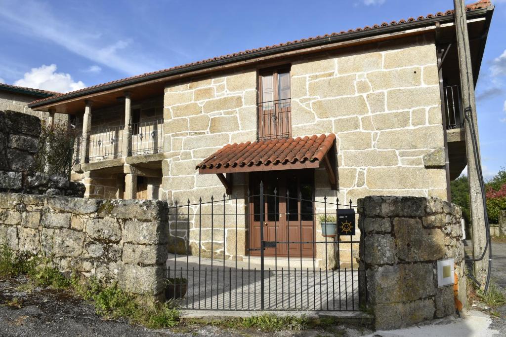 um edifício de pedra com uma cerca em frente em Ribeira Sacra II - Ourense em Nogueira de Ramuin