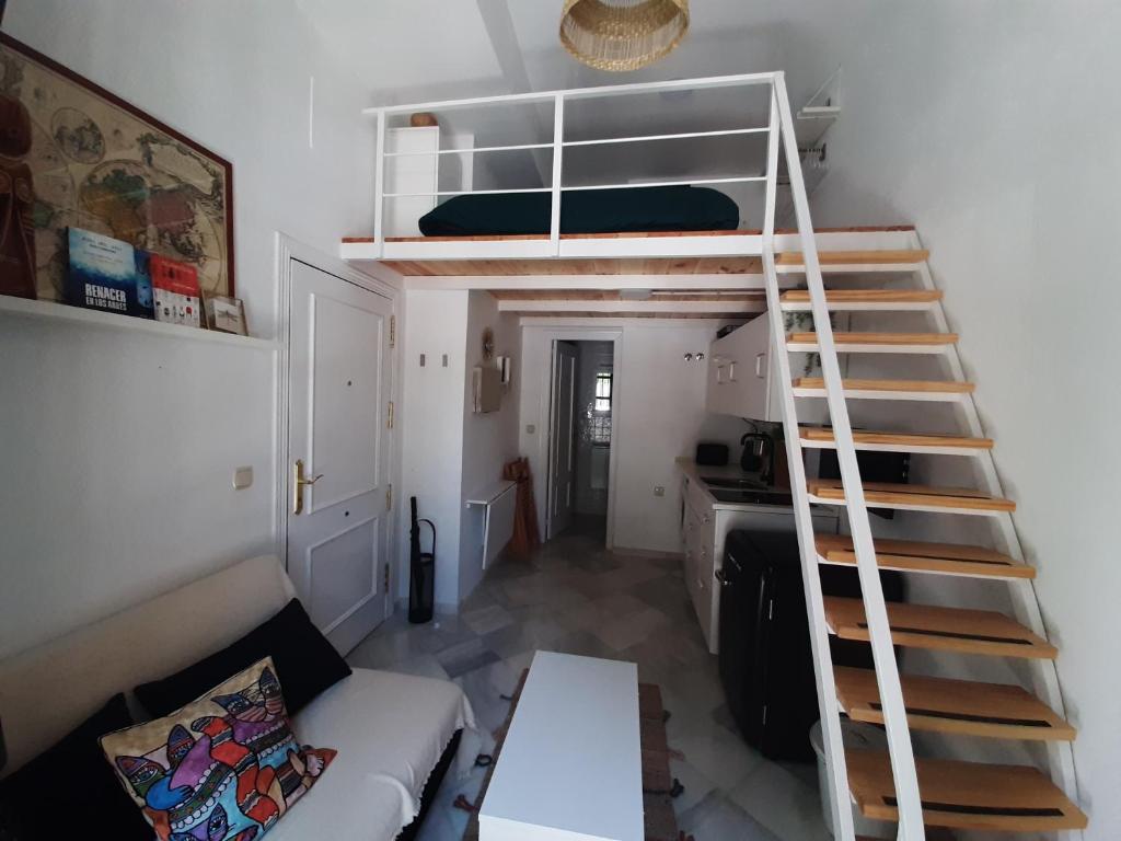 una sala de estar con una escalera que conduce a una litera en Suite Magallanes, en Sevilla