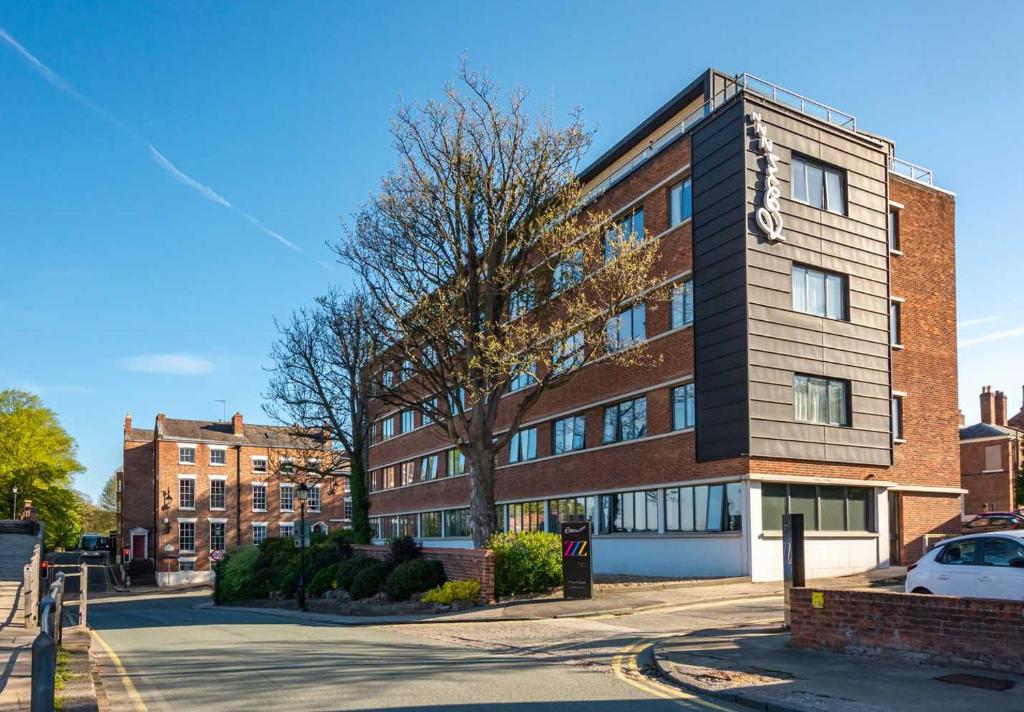 un edificio in mattoni con un'auto parcheggiata di fronte di Roomzzz Chester City a Chester