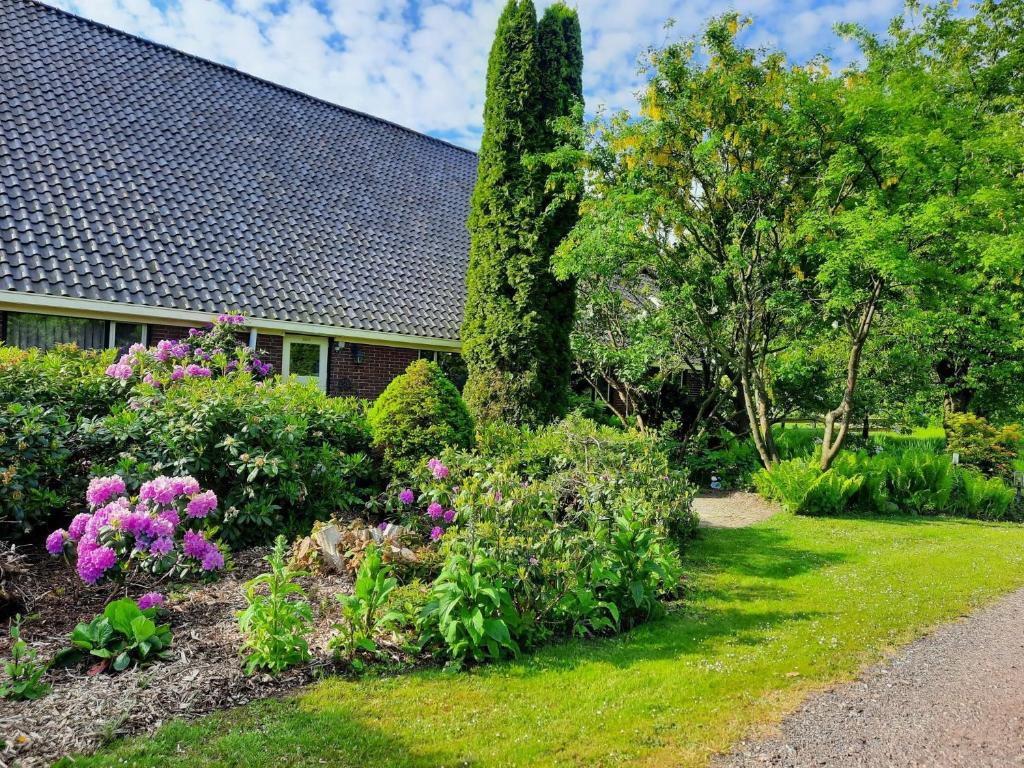 a garden with flowers and plants in front of a house at Vledderstee in Vledderveen