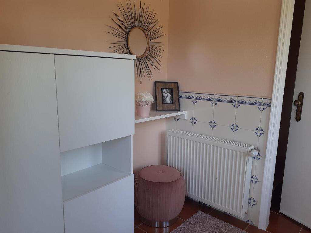 una stanza con radiatore bianco e specchio di Alojamento Local - Casa Amarela ad Alvaiázere