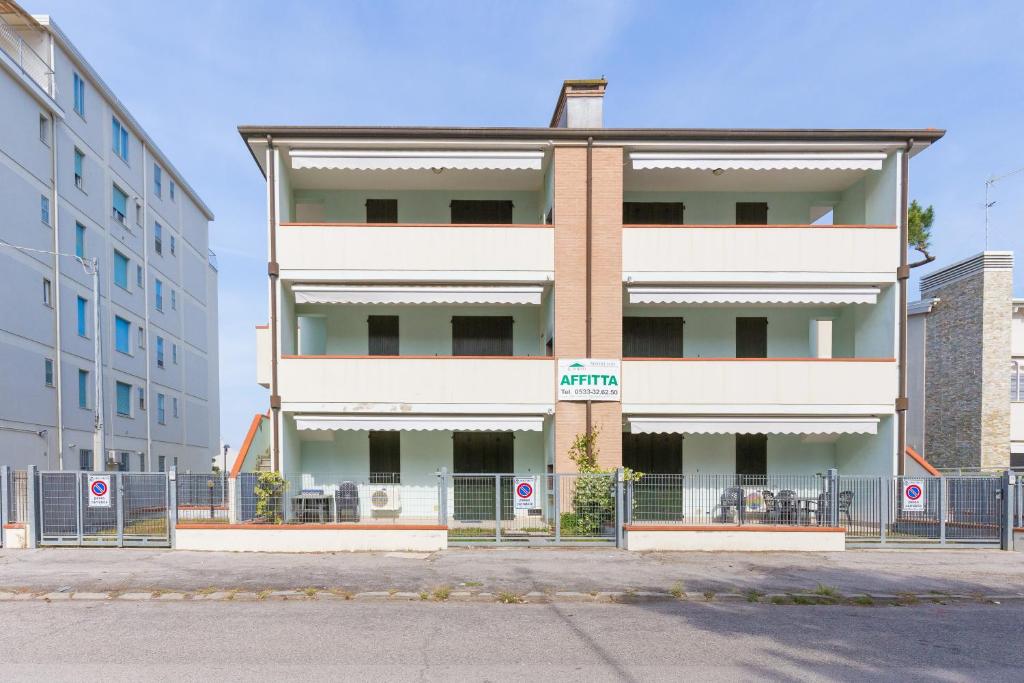 a tall white building with a fence in front of it at SMITH 2A in Lido degli Estensi