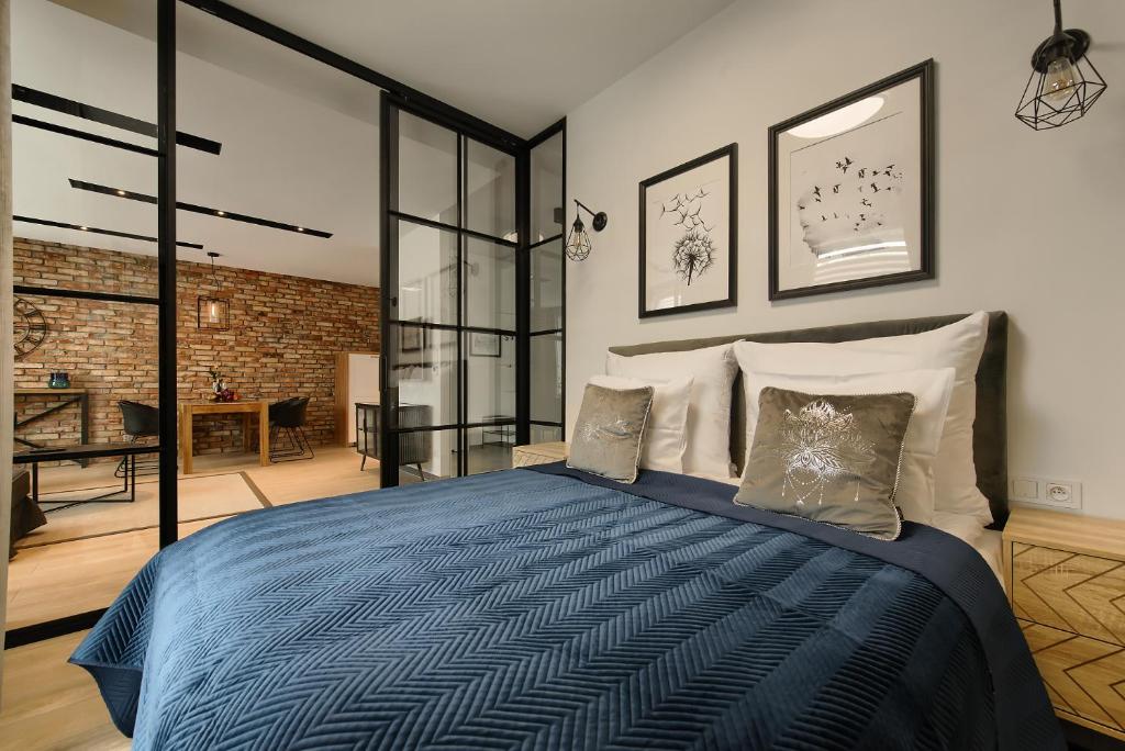 1 dormitorio con 1 cama con edredón azul en Zentrum Apartament IMPERO z Parkingiem, en Poznan