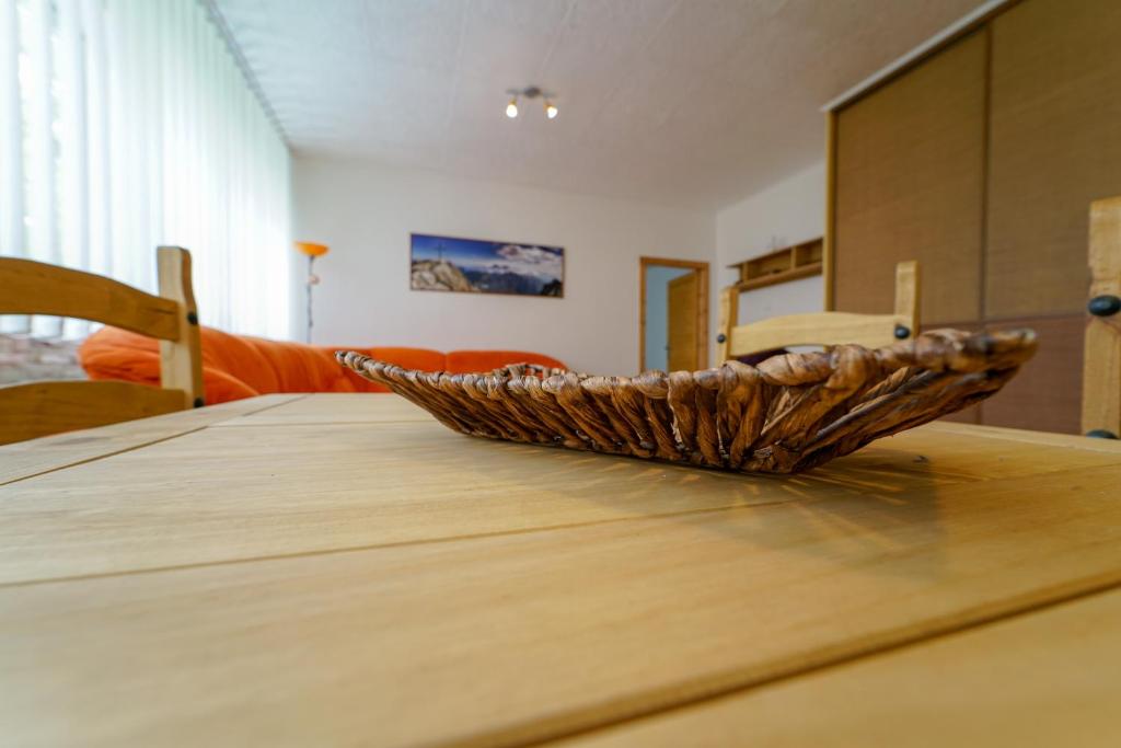 una mesa de madera con un bol encima en Víkendový byt v Tatranskej Lomnici, en Tatranská Lomnica