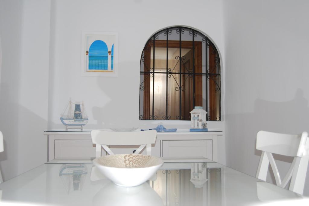baño blanco con lavabo y 2 sillas blancas en APARTAMENTO LA TORNA, en Nerja