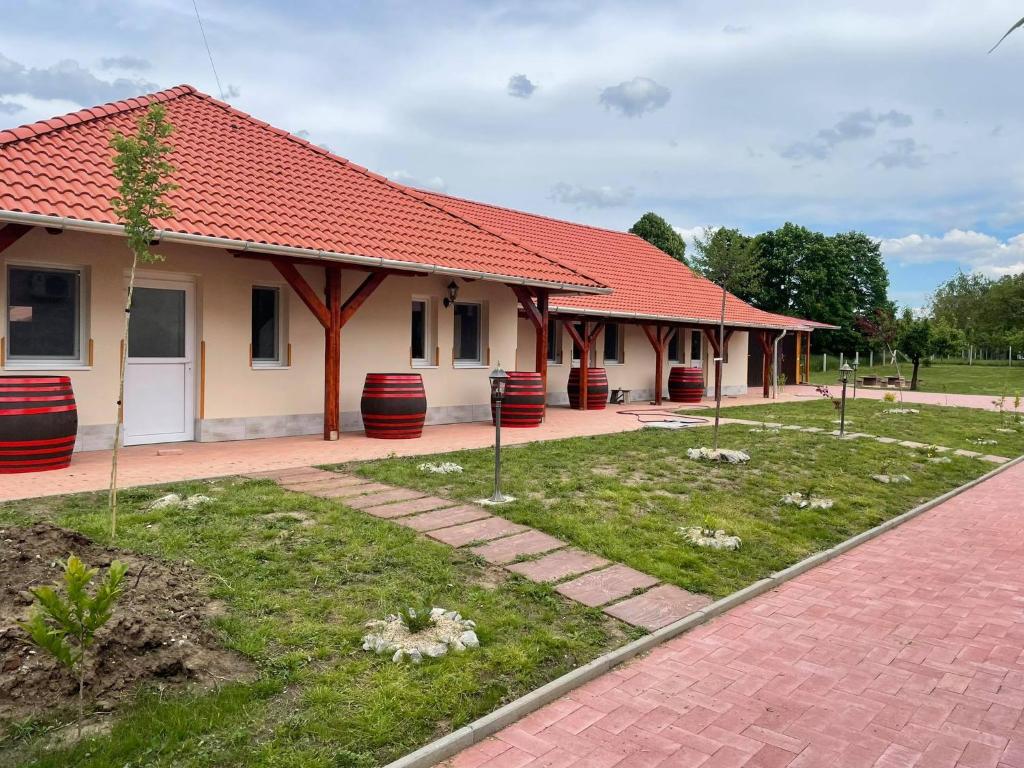 a house with a red roof and a courtyard at Tisza-i Apartmanok in Tiszafüred