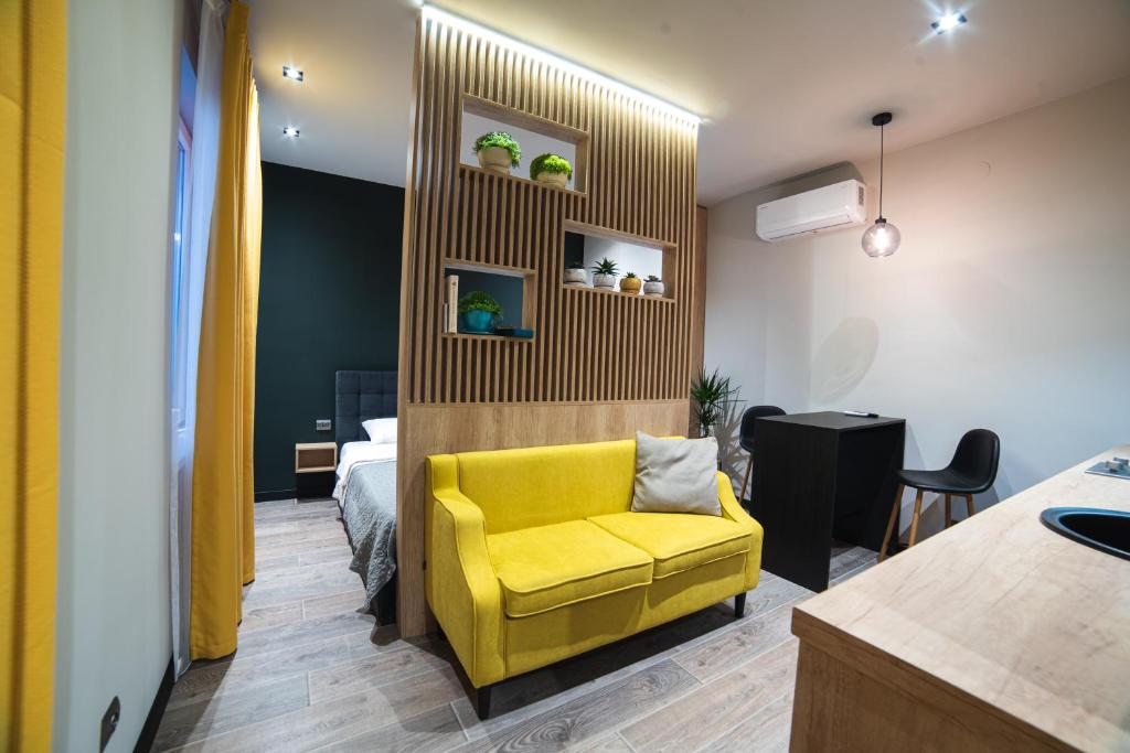 een gele stoel in een kamer met een slaapkamer bij Студія у центрі міста in Oezjhorod