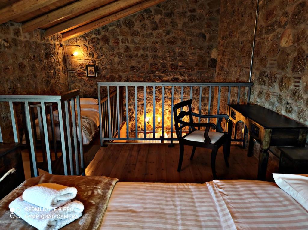 een slaapkamer met een bed, een bureau en een stoel bij Angelic in the mountains in Kaisárion